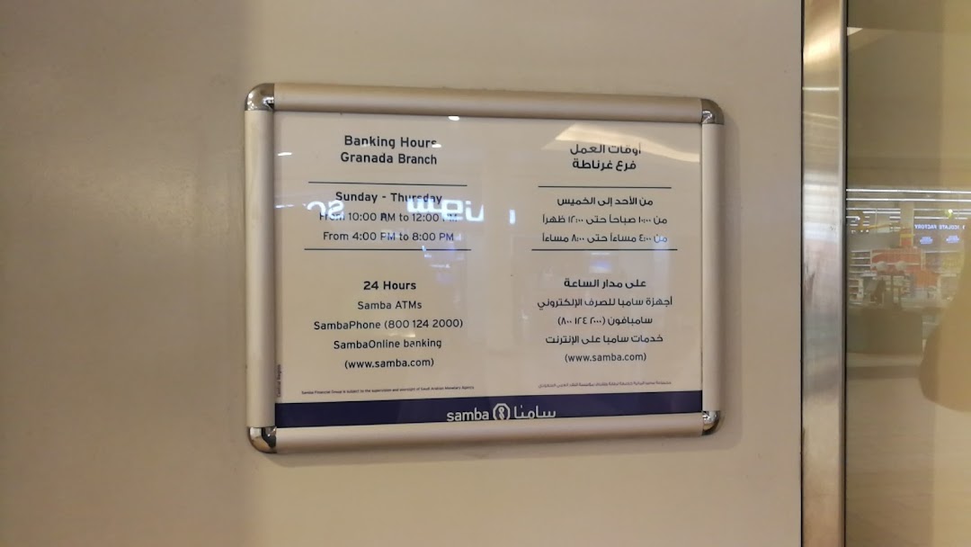 A sign displaying banking hours and services for SNB AlAhli's Granada Branch.