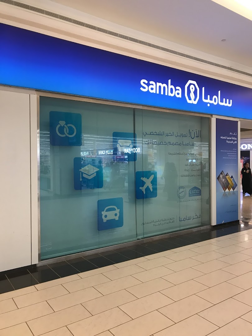 The exterior of a Samba bank branch with promotional graphics and text.