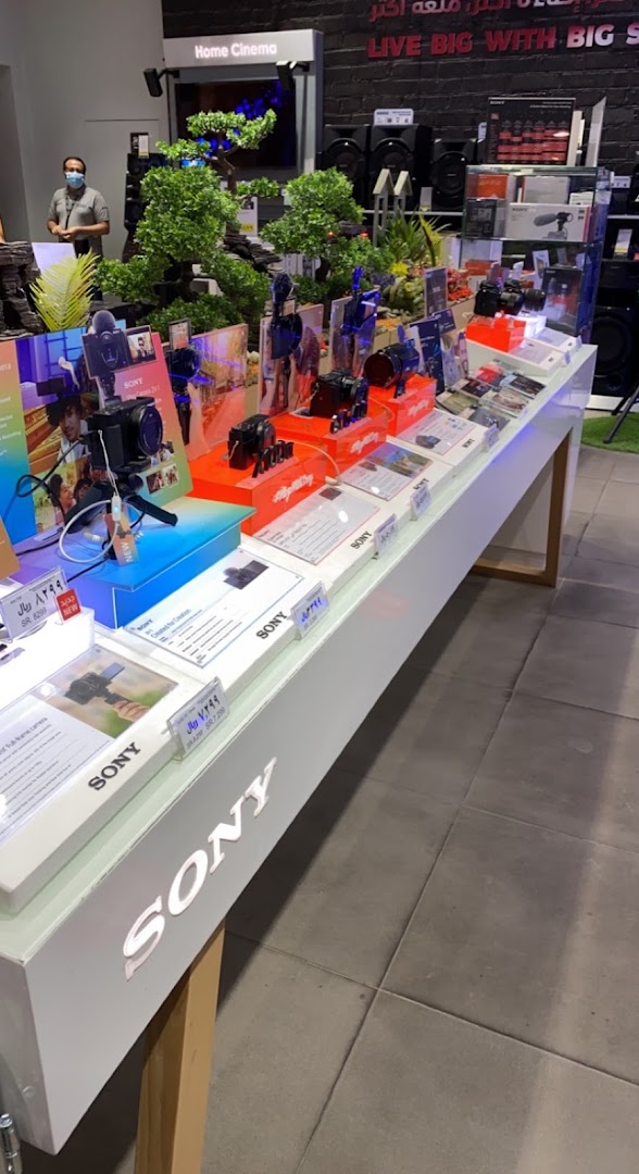 A display of Sony cameras and home cinema equipment in a modern electronics store.