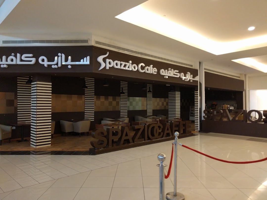 The exterior of Spazzio Cafe, featuring its prominent signage and inviting interior seating.