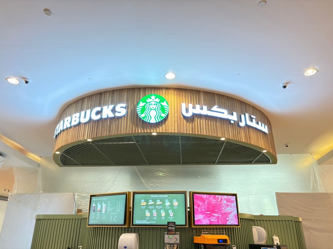 Starbucks storefront with illuminated signage and digital menu boards.