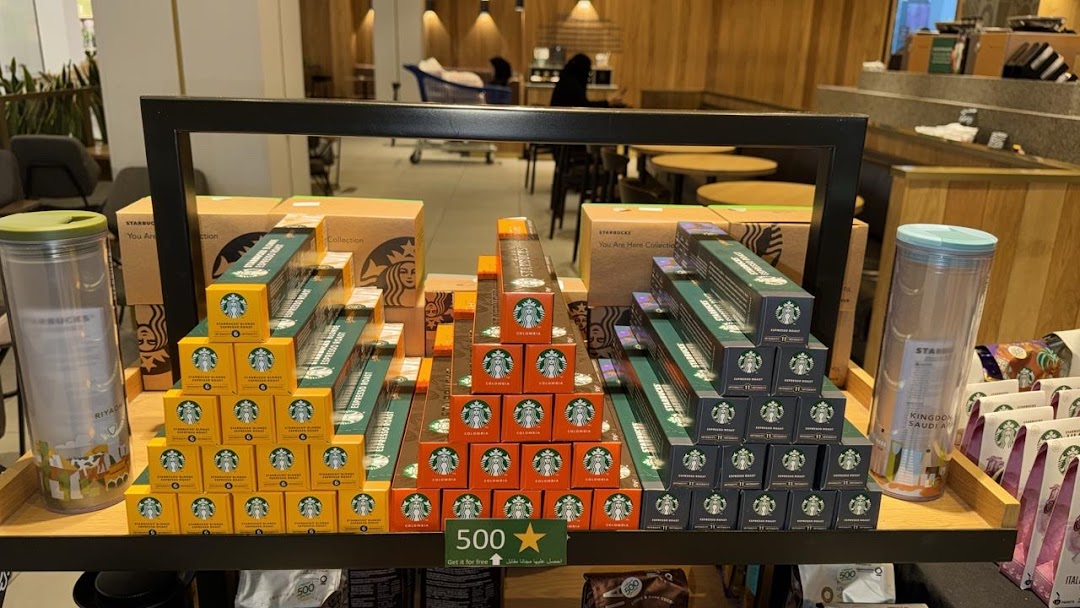Starbucks coffee pods and tumblers displayed pyramid-style on a shelf.