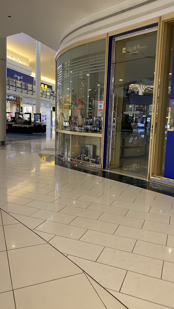 A modern retail store with a curved glass facade displaying merchandise inside.