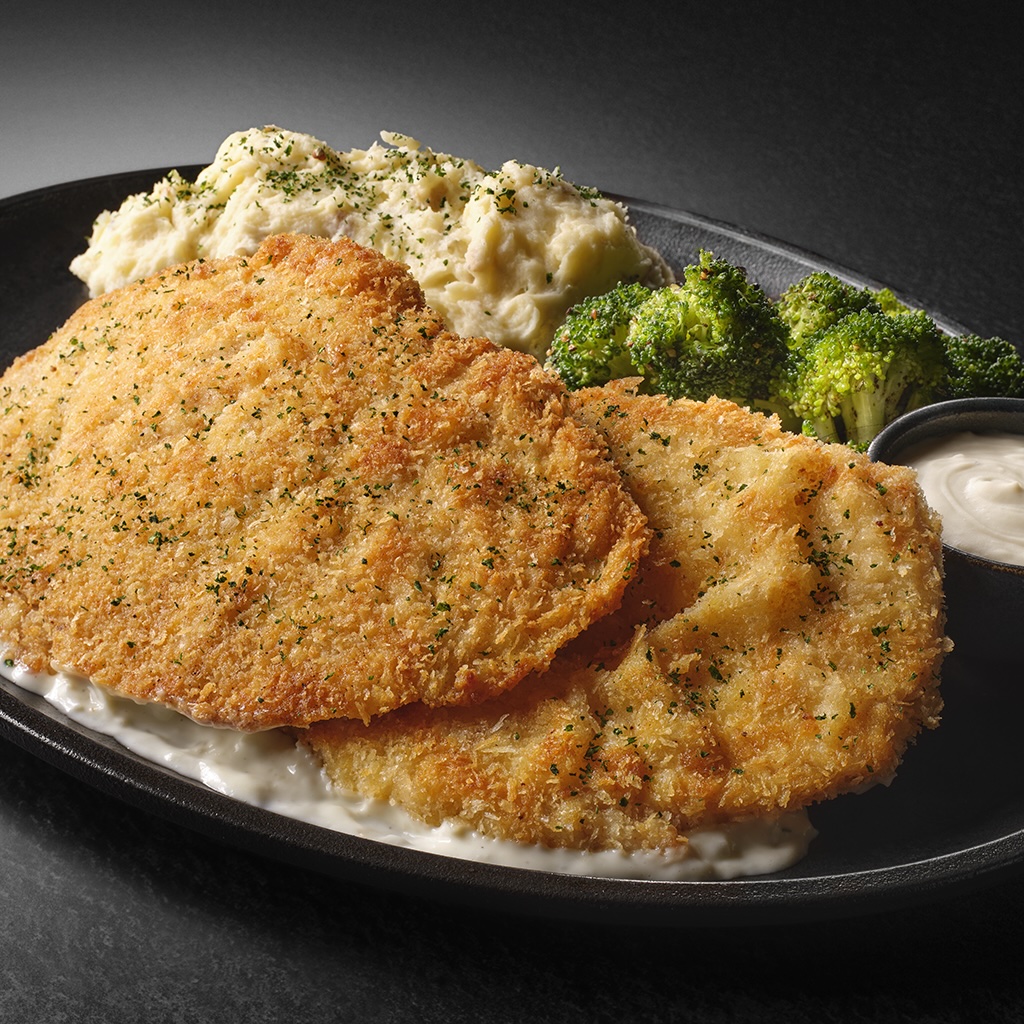 A plate of crispy breaded chicken with mashed potatoes and broccoli.