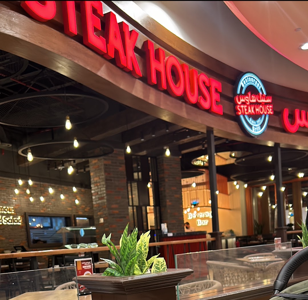 The Steak House restaurant entrance with prominent red signage and interior lighting.