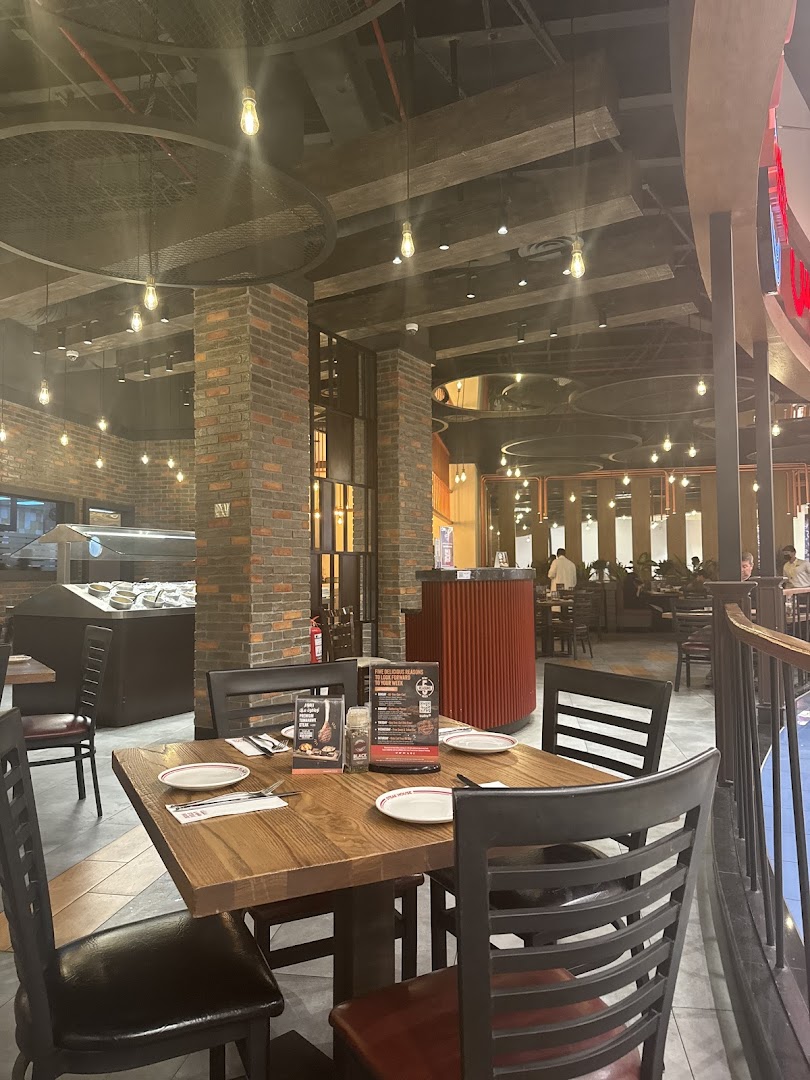 Interior view of a steakhouse with tables set and brick accents.