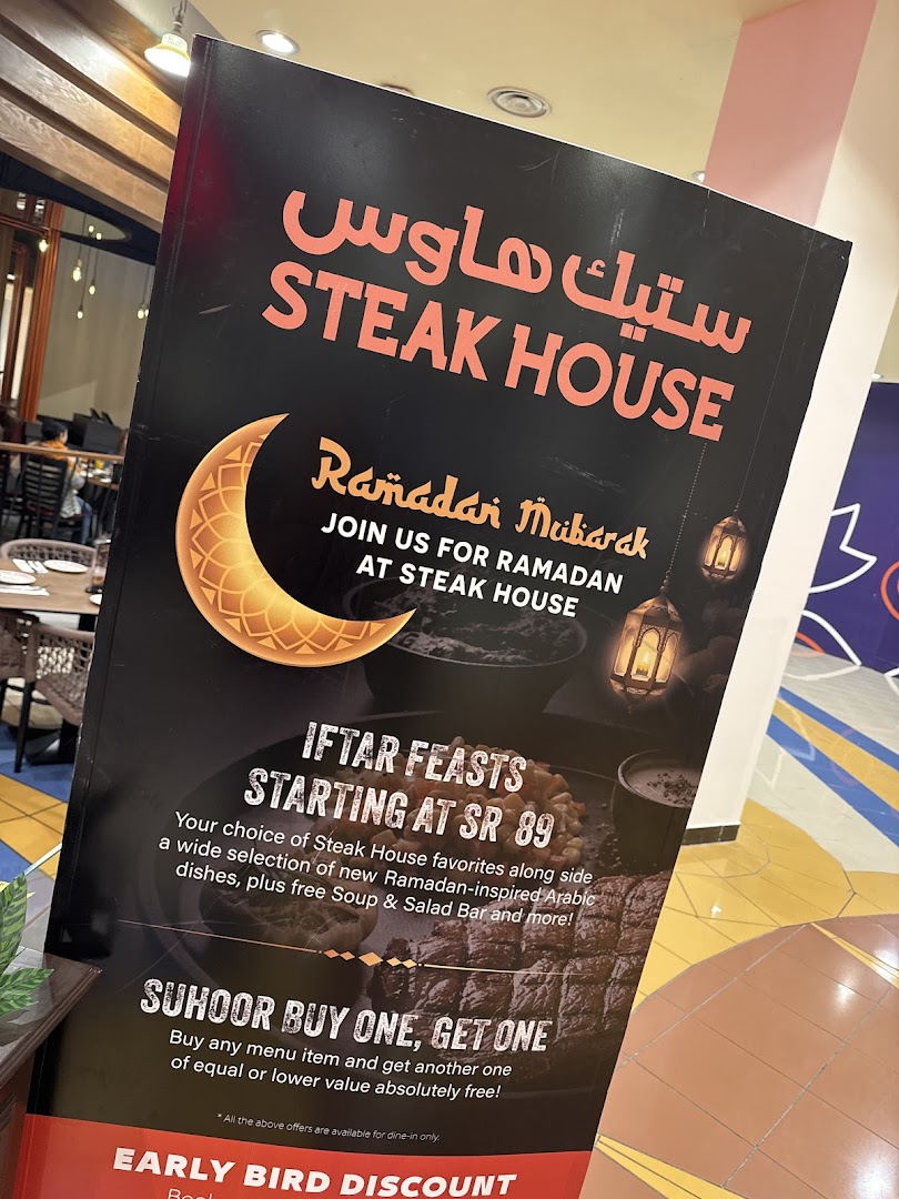 A promotional sign for Steak House featuring Ramadan offers like Iftar feasts and Suhoor buy one get one.