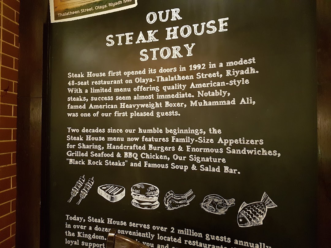 A black board detailing the history and menu highlights of a Steak House restaurant.