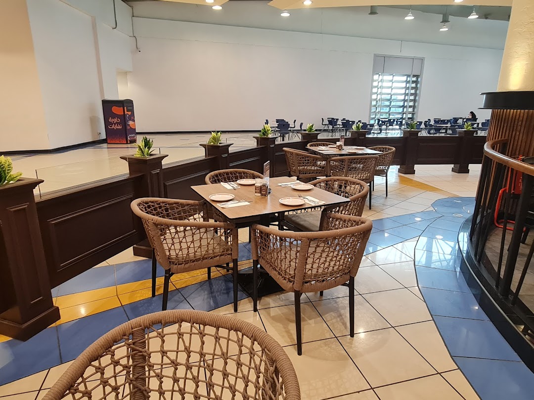 Interior view of a steakhouse with tables and chairs, featuring a modern and comfortable seating arrangement.