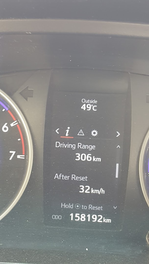 A car's dashboard displays outside temperature, driving range, and odometer reading.