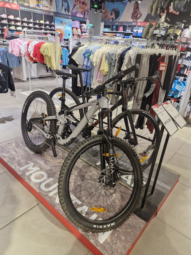 Display of mountain bikes and apparel inside a sports retail store.