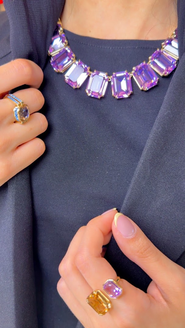 A person wearing a statement necklace and rings from Swarovski.