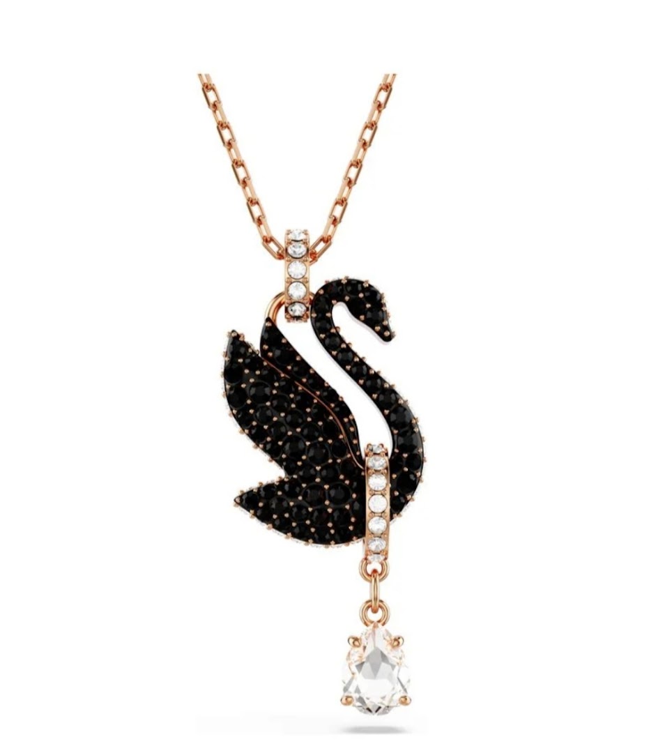 A close-up of a black swan pendant necklace with rose gold chain and clear crystals.