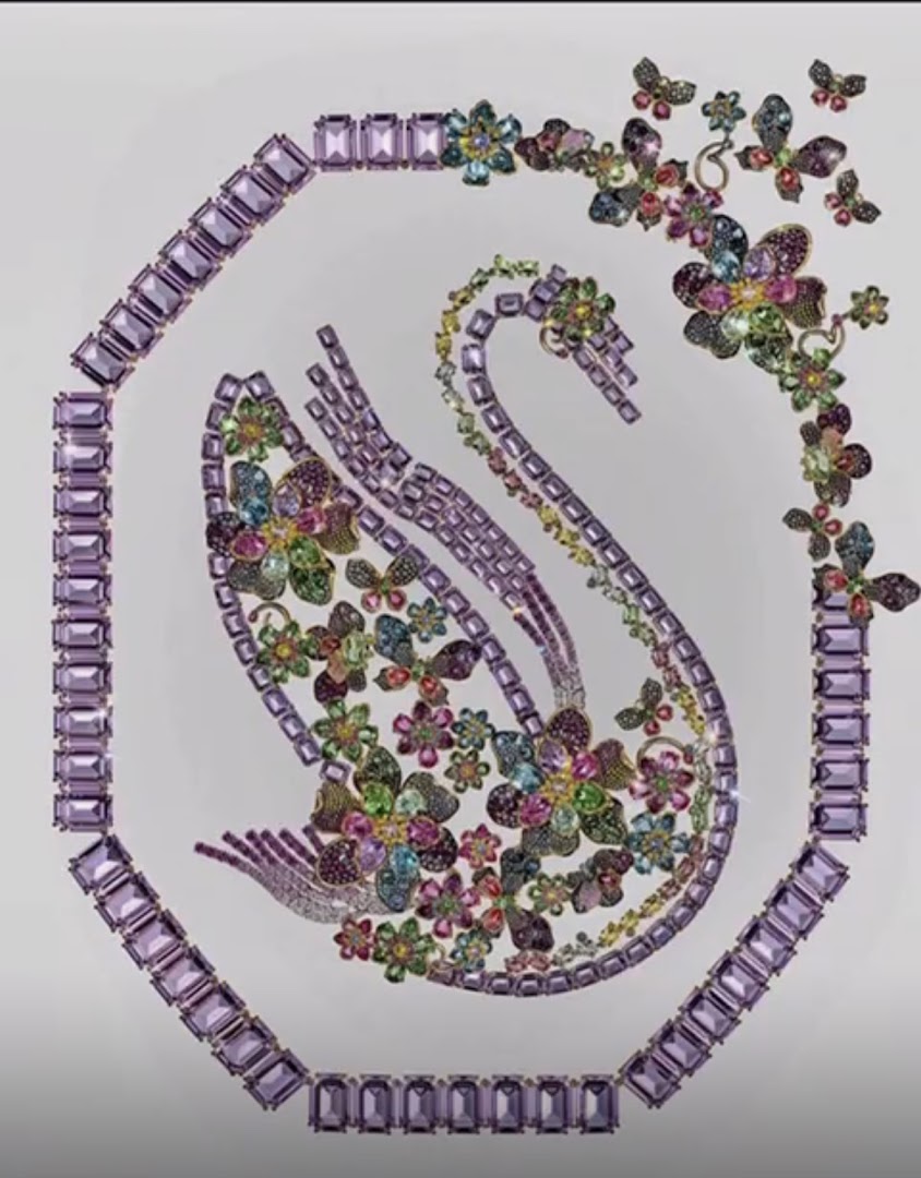 A stunning Swarovski jewelry piece shaped like a swan adorned with colorful gemstones and butterflies.