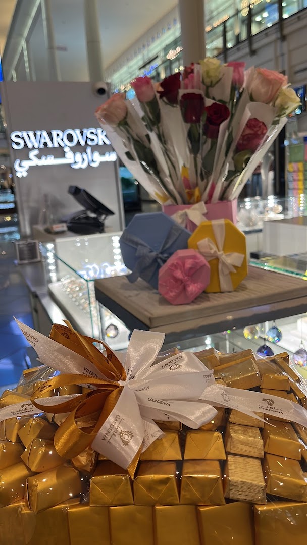 A display of chocolates and flowers in front of a Swarovski store.