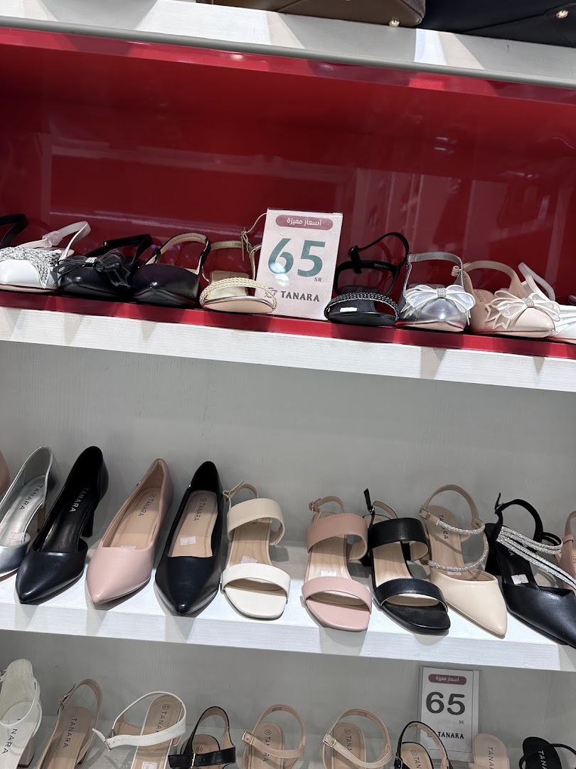 A display of various women's shoes, including heels and sandals, on shelves.