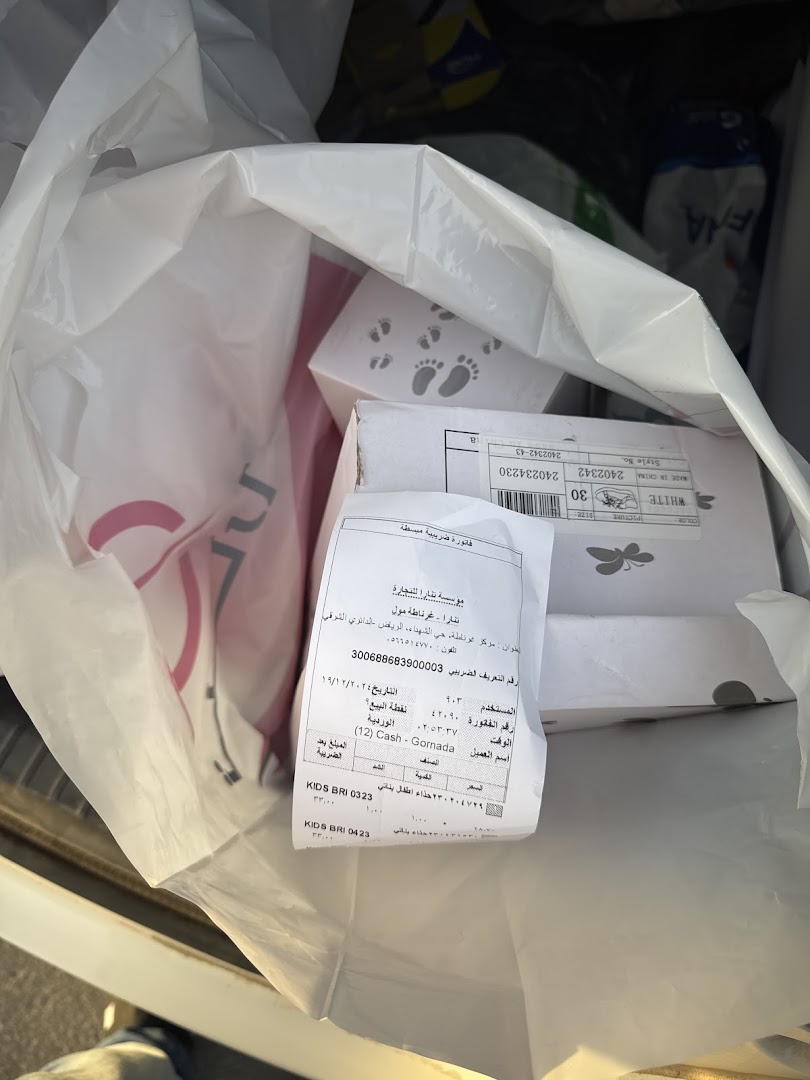 A shopping bag filled with items, including boxes with footprints and a receipt from Tanara.