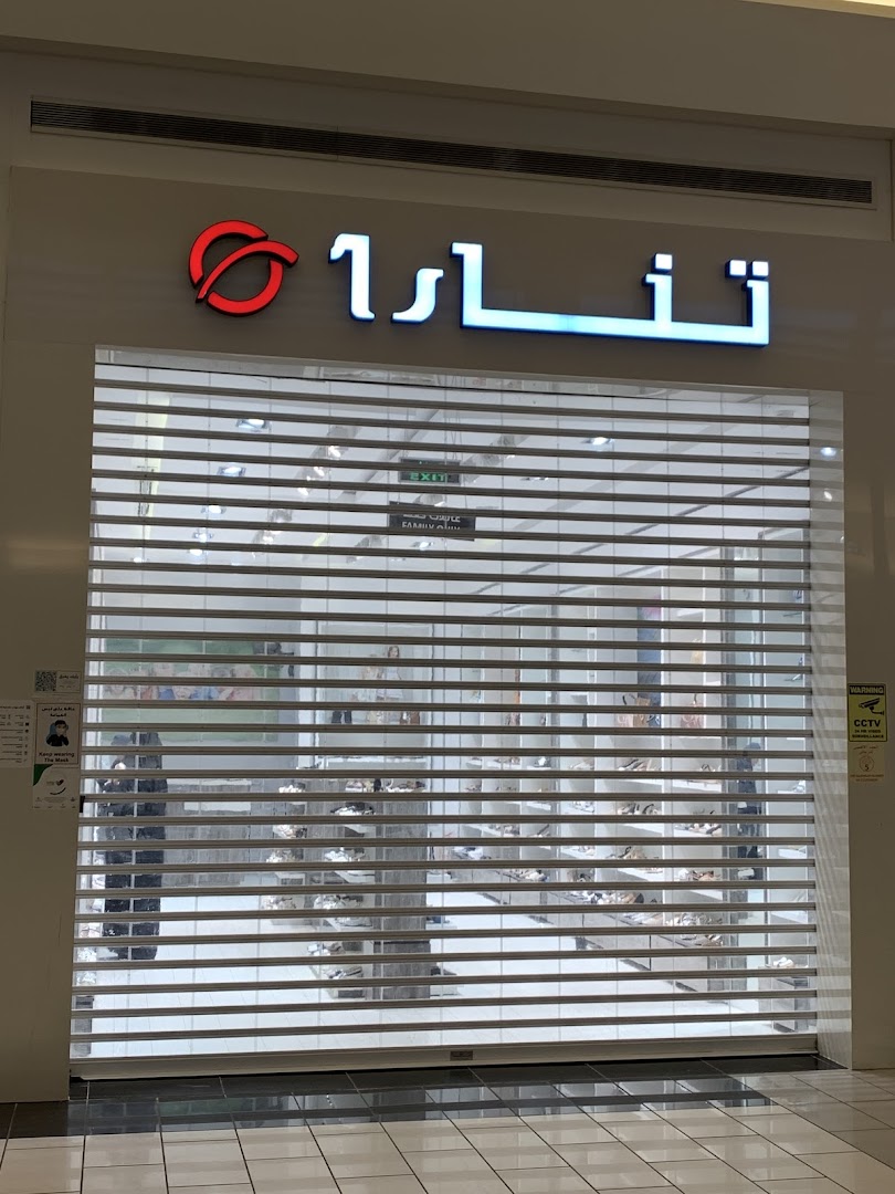 The TANARA shop front with its logo and a closed roller shutter displaying merchandise inside.