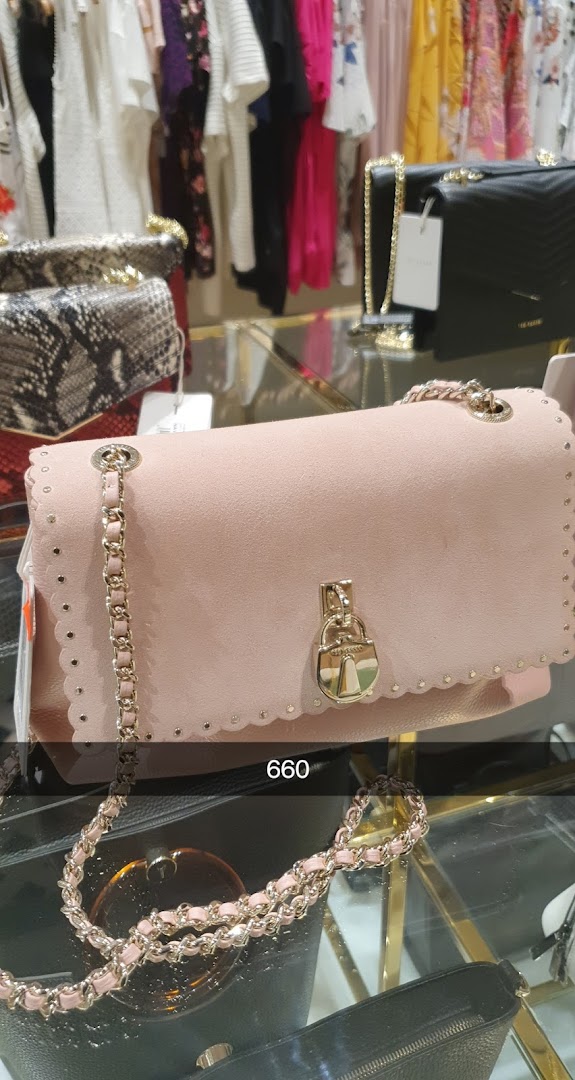 A display of stylish handbags and clothing in a retail store.