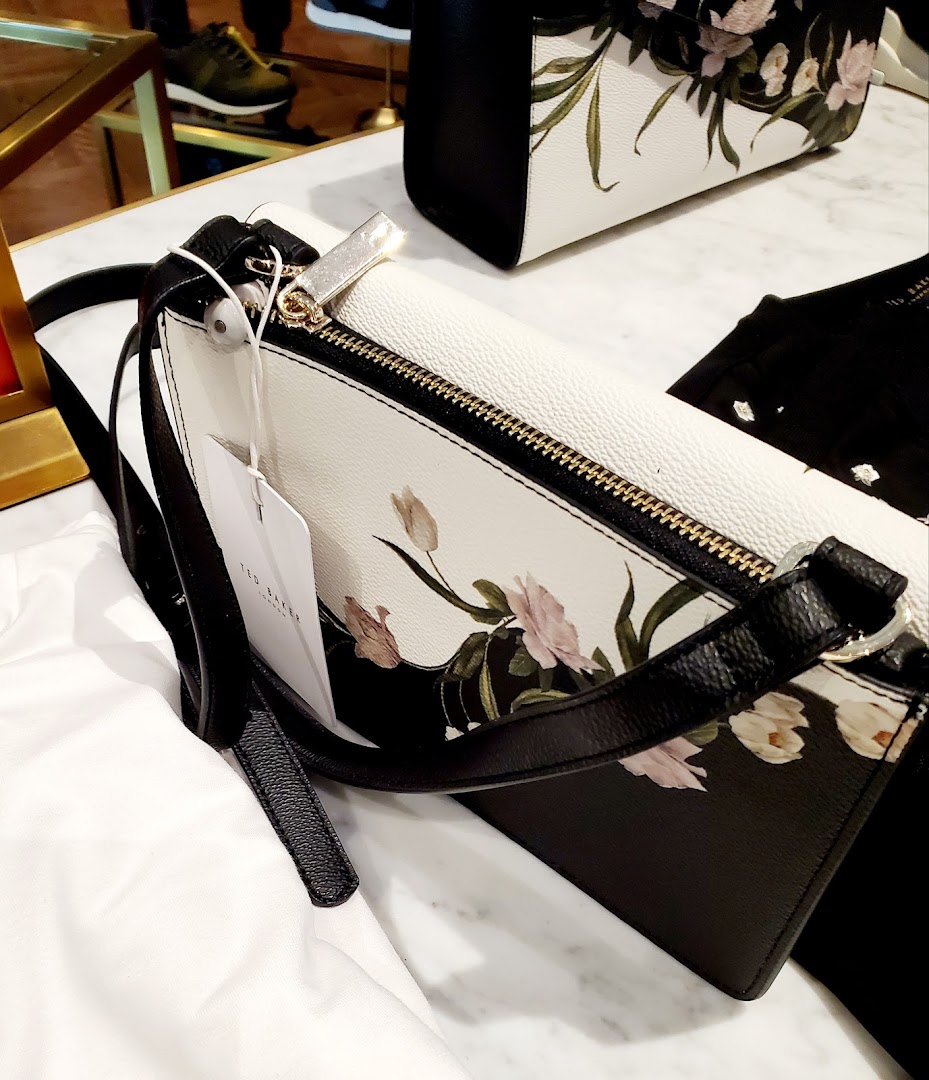 Close-up of Ted Baker handbags with a floral print and black accents.