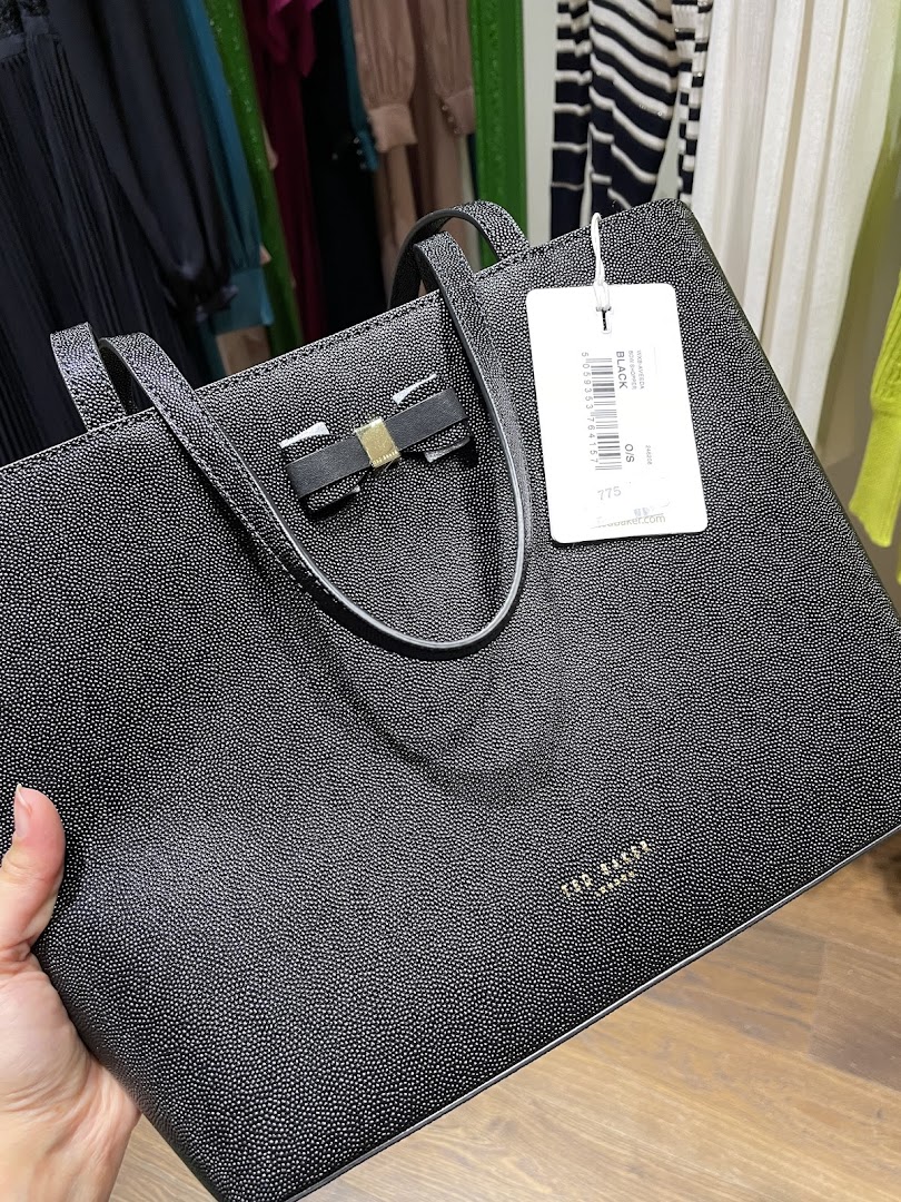 A black Ted Baker tote bag with a bow detail and a price tag.