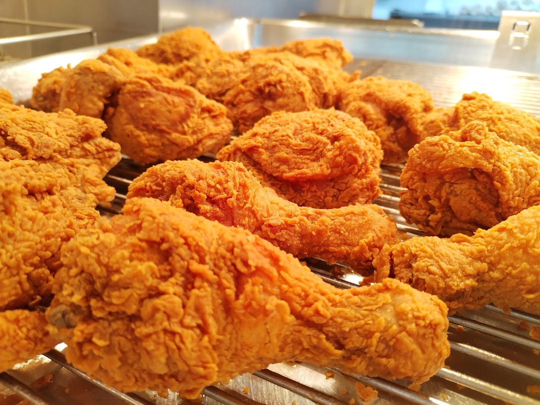 A close-up shot of freshly fried, golden-brown chicken pieces on a cooling rack.