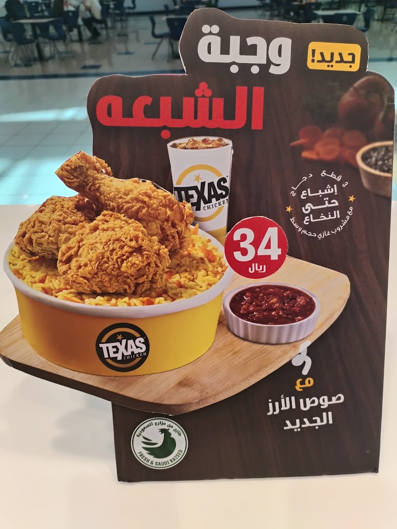 A promotional display for Texas Chicken featuring a meal with fried chicken, rice, a drink, and sauce.