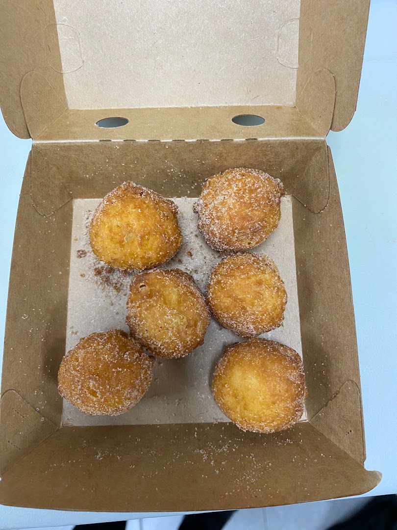 A box of six golden-brown, sugar-dusted donut holes.