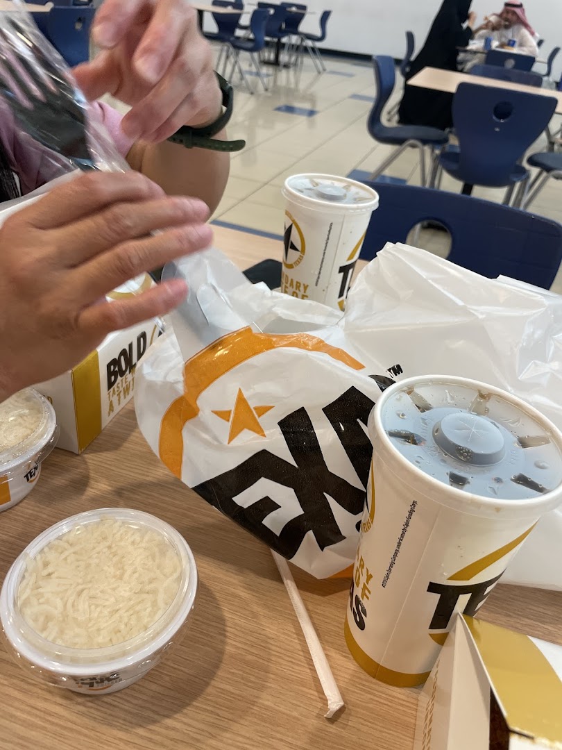 A table with Texas Chicken food items including drinks and rice.