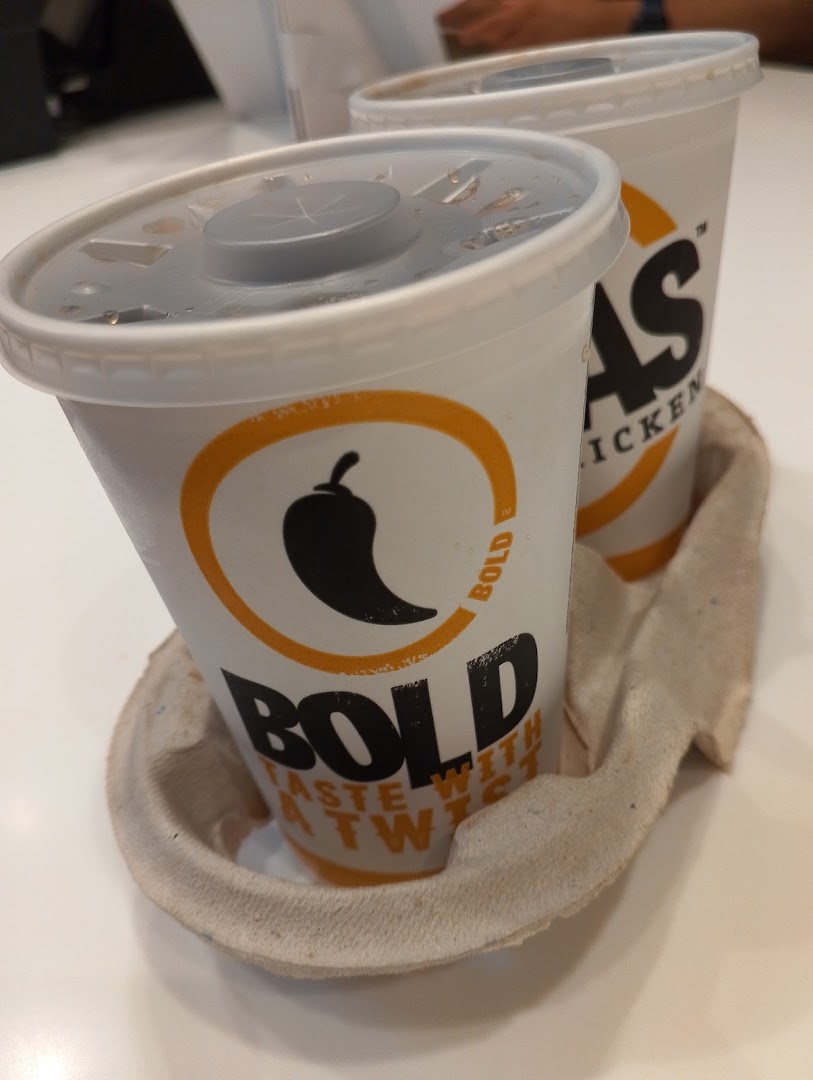 Two cups of Texas Chicken drinks in a cardboard holder on a white table.