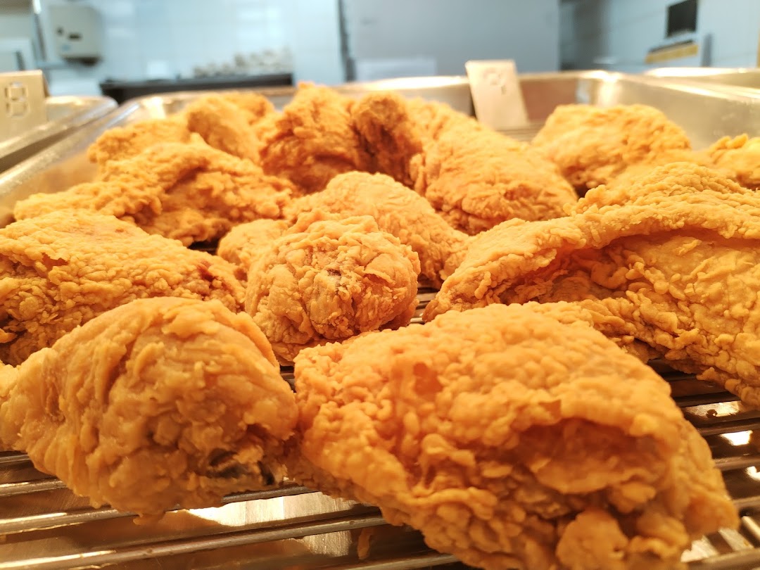 A close-up shot of crispy, golden-brown fried chicken pieces arranged on a metal rack.