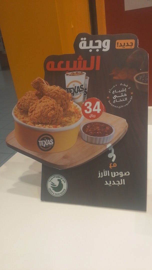 A promotional display for Texas Chicken featuring a meal with fried chicken and rice.