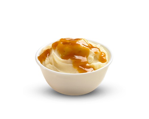 A bowl of creamy mashed potatoes topped with savory brown gravy.