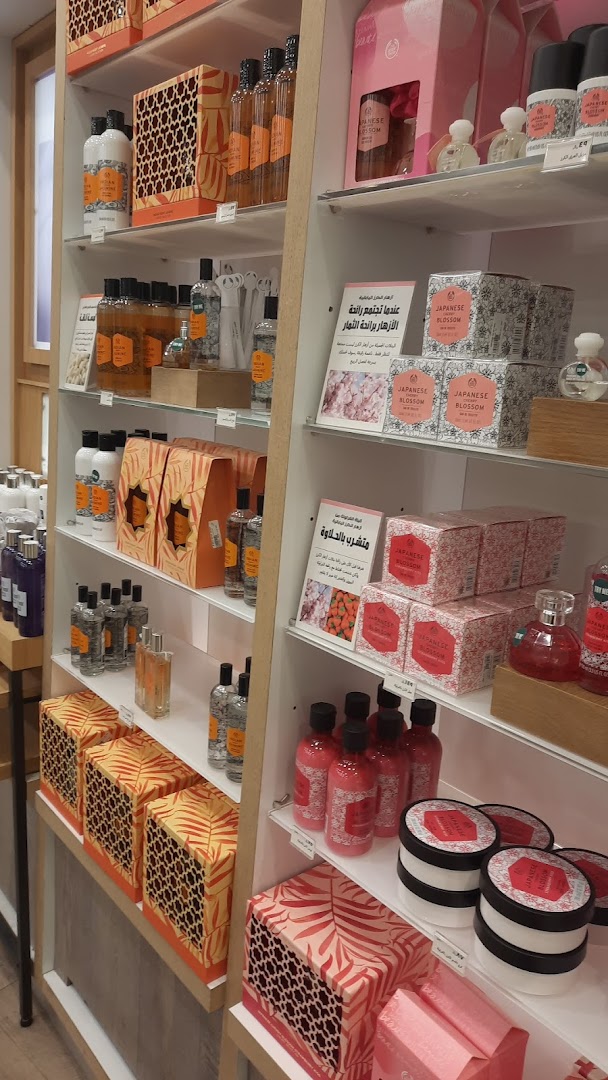 Shelves stocked with various Body Shop products, including lotions, perfumes, and gift sets.