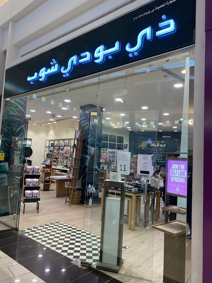 The Body Shop storefront with products displayed inside and a 'Join the Self Love Uprising' sign.