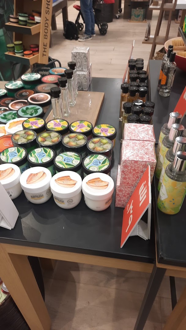 A display of various Body Shop products including creams, lotions, and gift sets.