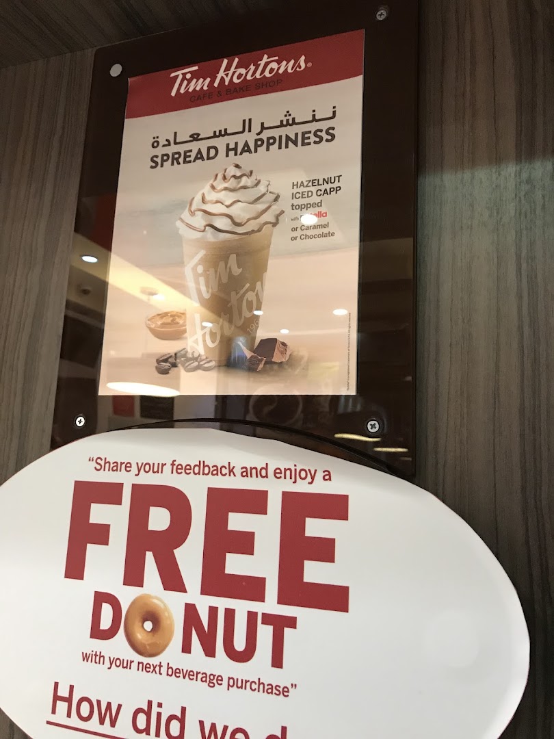 Tim Hortons advertisement featuring a Hazelnut Iced Capp and a free donut offer.