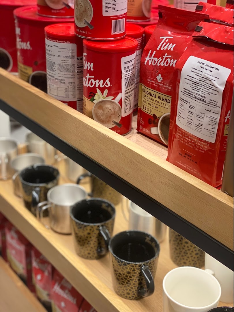 Shelves stocked with Tim Hortons coffee bags, cans, and mugs.