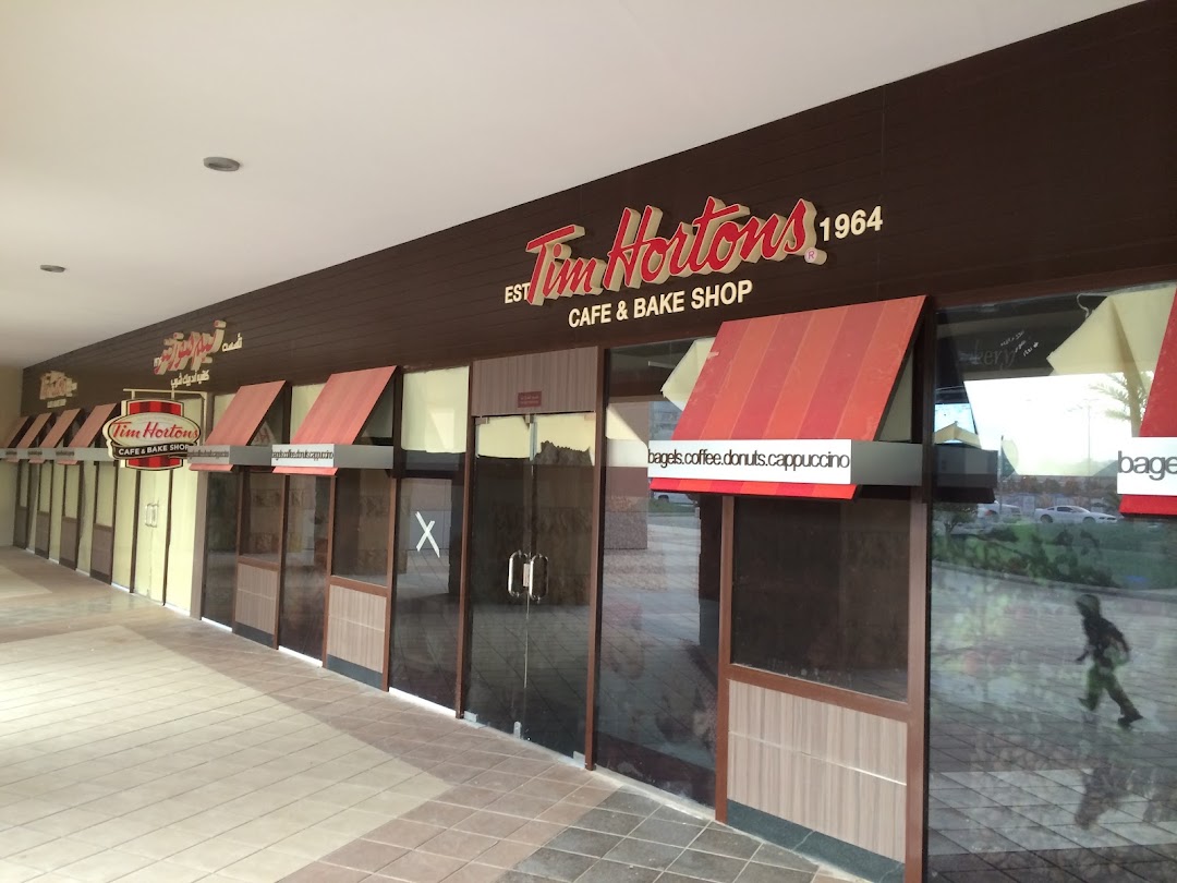 Exterior view of a Tim Hortons cafe and bake shop with its prominent signage.