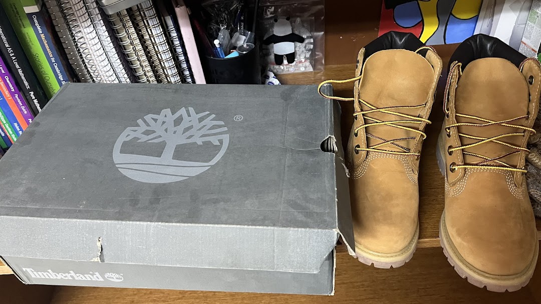 A Timberland shoe box and a pair of classic Timberland boots on a shelf.