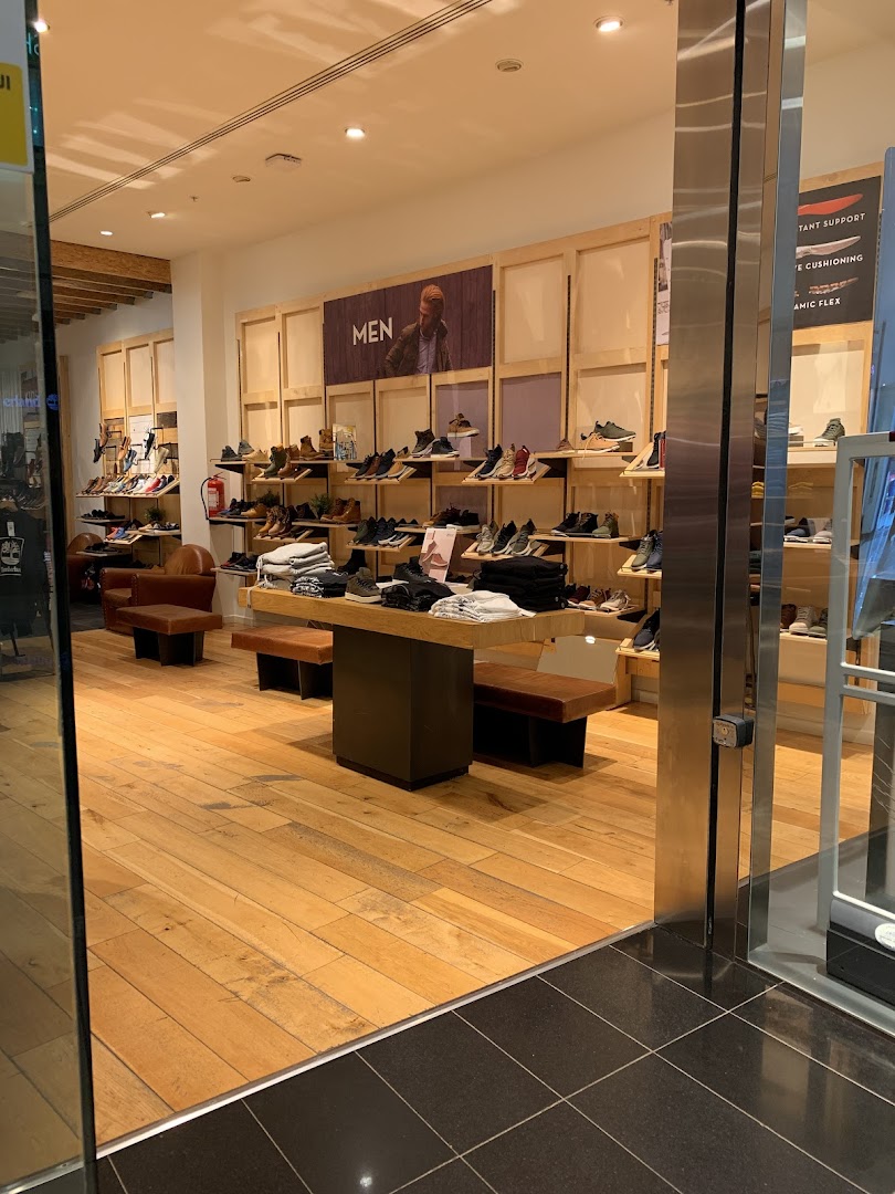 Interior view of a Timberland store showcasing men's footwear and apparel.