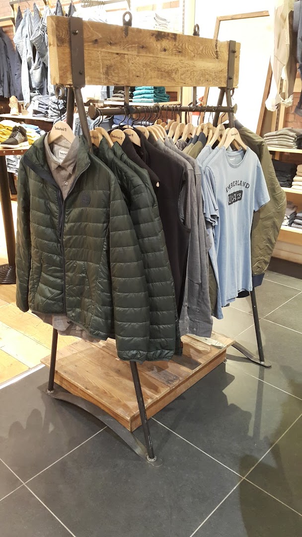 A rack of Timberland jackets and t-shirts displayed in a store.