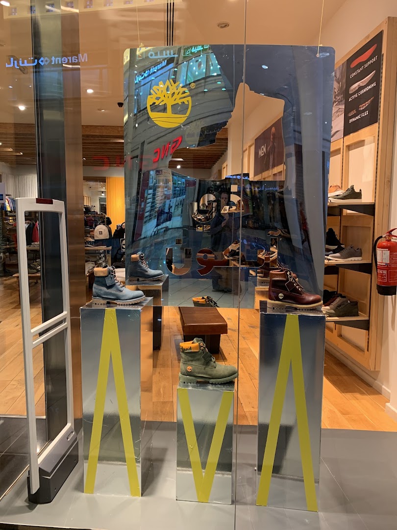 Timberland shop window display featuring boots on silver pedestals with yellow accents.