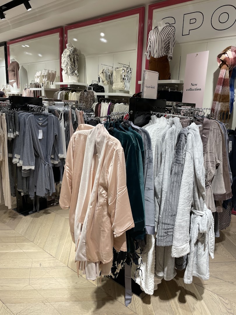 A retail shop interior displaying a variety of robes and loungewear on racks.