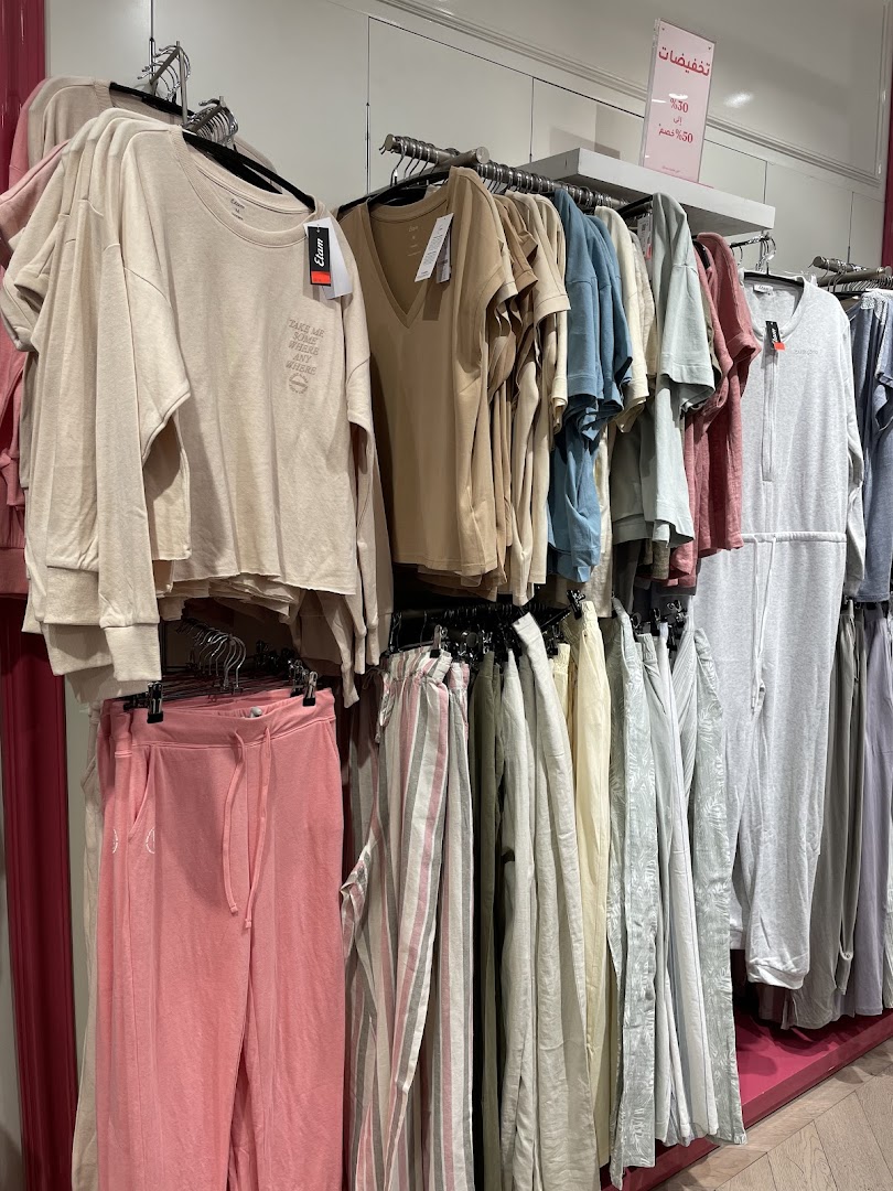 A display of casual women's clothing, including loungewear and tops, in various pastel colors.