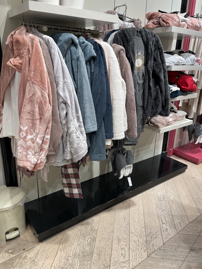 Cozy loungewear and robes displayed on hangers and shelves in a retail store.