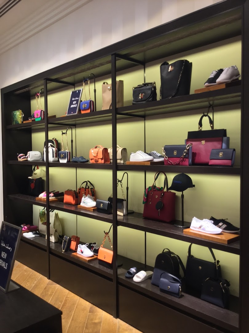 Shelves display a variety of Tommy Hilfiger handbags, shoes, and accessories.