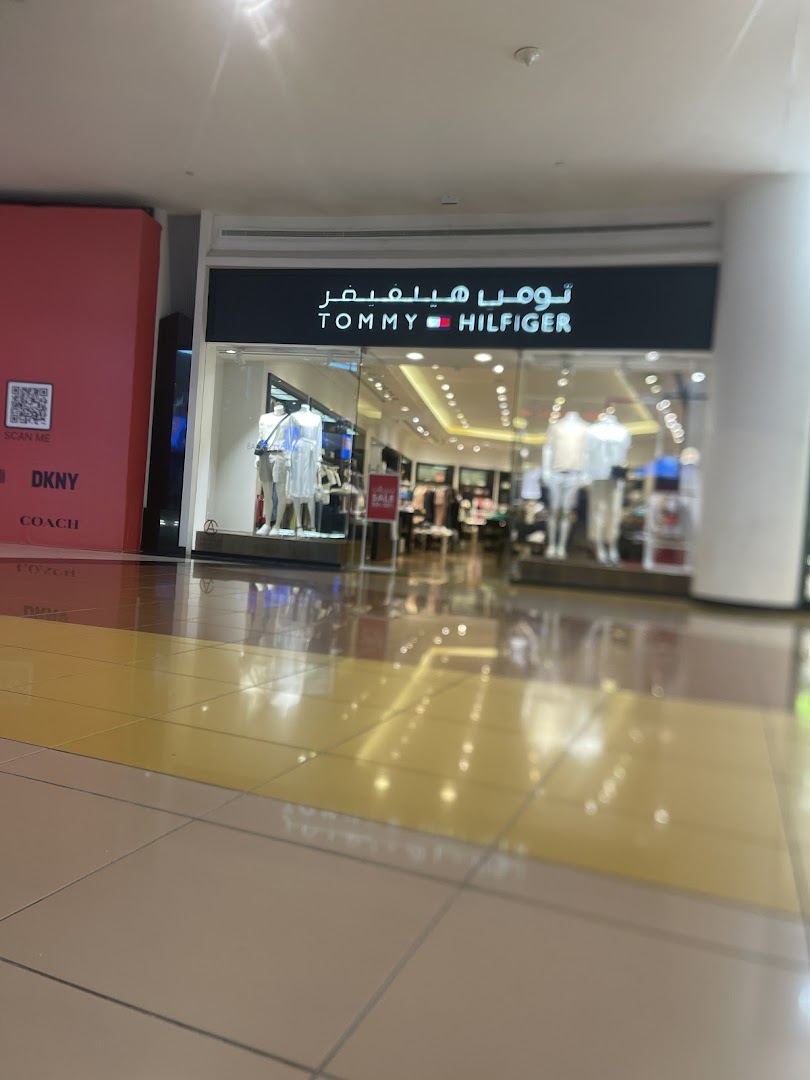 The Tommy Hilfiger store entrance with mannequins displaying clothing and the brand's logo.