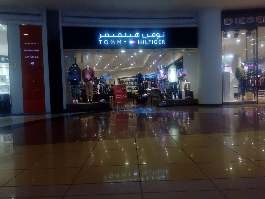 The Tommy Hilfiger store entrance with mannequins displaying clothing and a special offer sign.