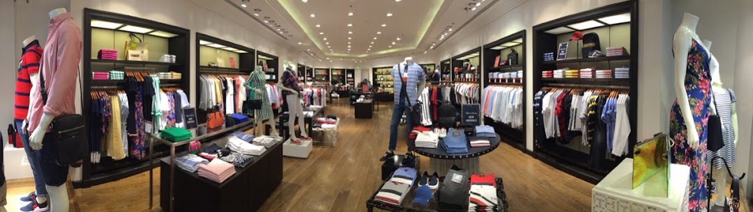 Interior view of a Tommy Hilfiger store showcasing men's and women's apparel on racks and mannequins.